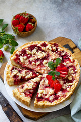 Delicious summer dessert strawberry pie with crumble, sweet delicious holiday cake with strawberry on a light stone or slate table. Copy space for your text.