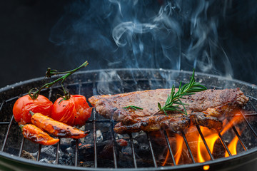 Steak on the grill with flames With Rosemary Pepper And Salt - Barbecue,Food and health care concept