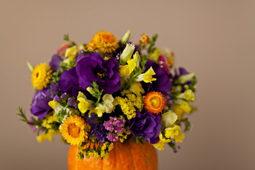 Autumn floral bouquet in a pumpkin vase for Halloween