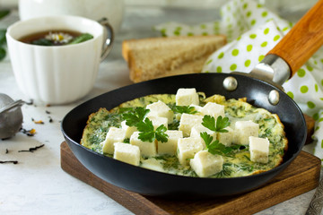 Breakfast background. Fried eggs with spinach, feta cheese on stone table.