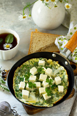 Breakfast background. Fried eggs with spinach, feta cheese on stone table.