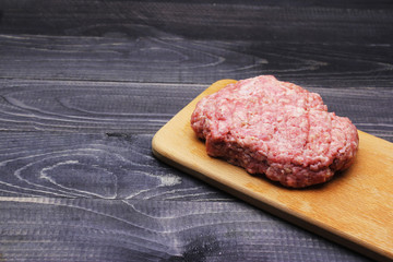 Burger. minced meat on cutting board on black table top with copy space