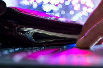 Glowing high speed internet optical fibres, opened wallet on computer keyboard, caucasian man hand...