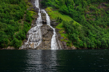 Fototapeta premium The Seven Sisters unique waterfall at Geirangerfjord seens by boat trip, Sunnmore region, Norway, most beautiful fjords in the world, included on the UNESCO World Heritage.