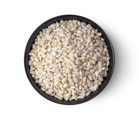 Heap of pearl barley in black bowl isolated on white background. top view
