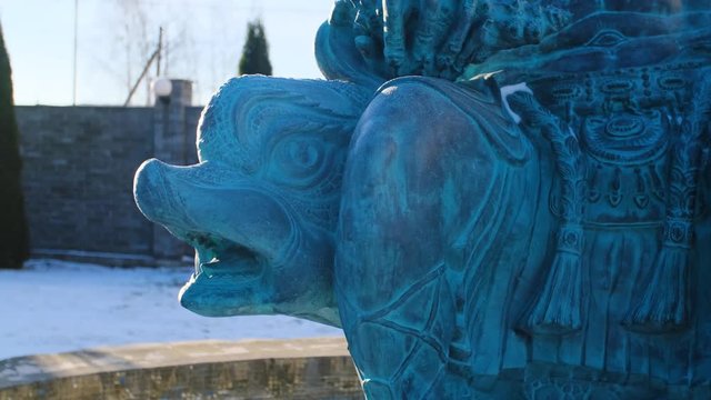 Close-up of statue of Neptune. Stock footage. Part of sculpture of Poseidon sitting on Dolphin. Head of screaming Dolphin under weight of Neptune. Statue of ancient Greek God of seas