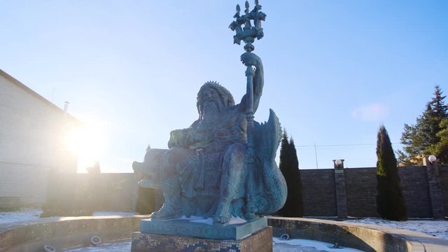 Fountain statue of Neptune in winter. Stock footage. Beautiful sculpture of Neptune sitting on dolphin stands in inactive fountain in winter