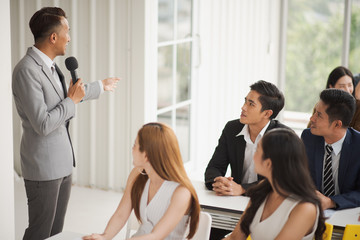 Young Asian business people seminar group are listening the speaker in meeting room which feeling happy, The audiences look at the speaker. trainer are coaching the team. seminar and training concept.