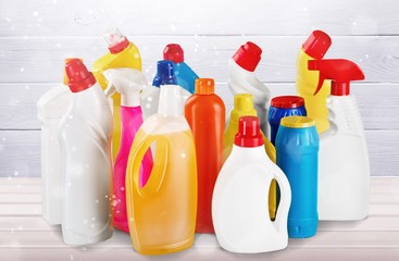 Plastic bottles and cleaning equipment on white background