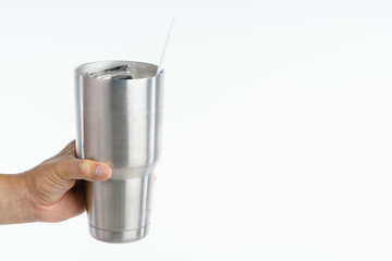 Hand holding stainless steel thermos mug