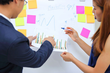 Young confident business colleagues analyzing documents and working together in office.