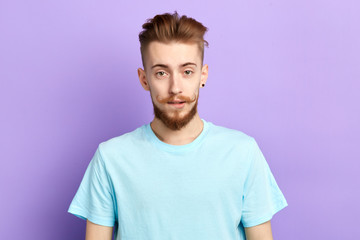 handsome good loking man with stylish moustache looking at the camera. close up portrait. isolated blue background. studio shot.beauty, fashion concept