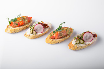 Canape mini bruskety sandwiches with fresh and steamed vegetables. Beautifully decorated catering banquet menu. Food snacks and appetizers for buffet. Isolated on white background