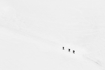 Three lonely isolated climbers climbing a mountain in French Alps near Chamonix