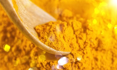Ground Turmeric powder with wooden spoon