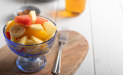 freshly made fruit salad in a blue bowl on a white background