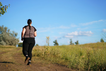 Weight loss, outdoor activity, exercising, healthy lifestyle, jogging. Overweight woman running on summer meadow