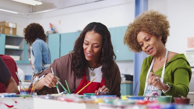 Two Mature Female Students Attending Art Class In Community Centre 