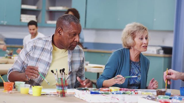 Group Of Retired Seniors Attending Art Class In Community Centre 