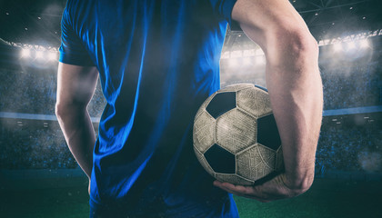 Soccer player ready to play with ball in his hands at the stadium