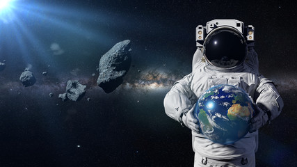 Obraz na płótnie Canvas astronaut protecting planet Earth from asteroids