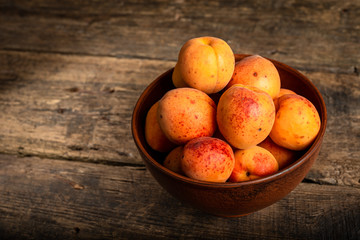 fresh apricots in a basket on a wooden table