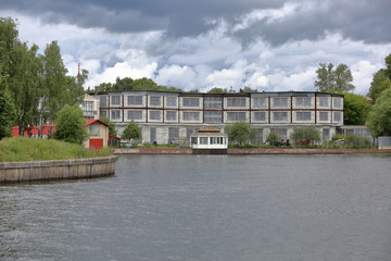 Unfinished stone house by the river on a cloudy summer day