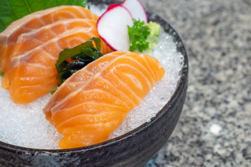 salmon sashimi on ice in black bowl japanese food