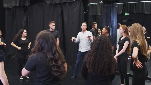 Teacher With Drama Students At Performing Arts School In Studio Improvisation Class