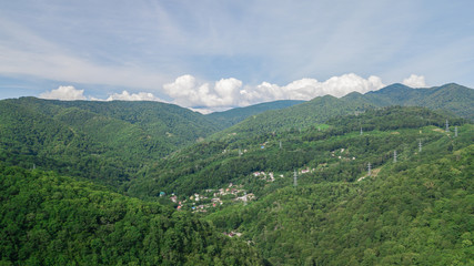 Naklejka premium Birds Eye View - winding road from the high mountain pass in Sochi, Russia. Great road trip trough the dense woods.