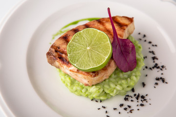 Grilled fish fillet salmon. Selected pieces of red fish with champagne and spinach risotto. Seafood. Banquet festive dishes. Fine dining restaurant menu. White background.