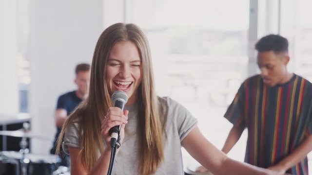 Students At Performing Arts School Playing In Band At Rehearsal 