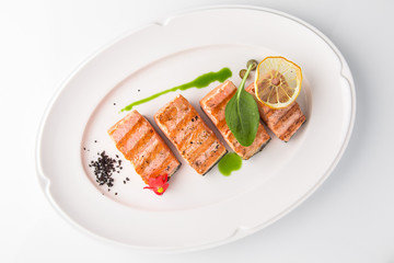 Grilled fish fillet salmon. Selected pieces of red fish. Seafood. Banquet festive dishes. Fine dining restaurant menu. White background.