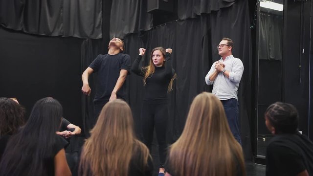 Teacher With Drama Students At Performing Arts School In Studio Improvisation Class
