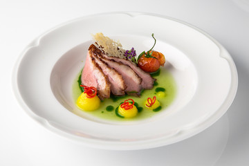 Sliced pork carving in sauce with mashed potatoes and grilled vegetables. Banquet festive dishes. Fine dining restaurant menu. White background. 