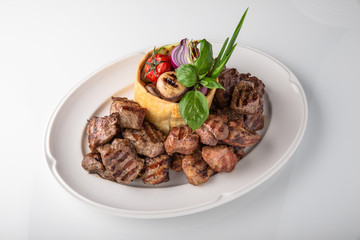 Skewers of pork, beef with vegetables and mushrooms. Grilled meat. Banquet festive dishes. Fine dining restaurant menu. White background. 