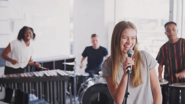 Students At Performing Arts School Playing In Band At Rehearsal 