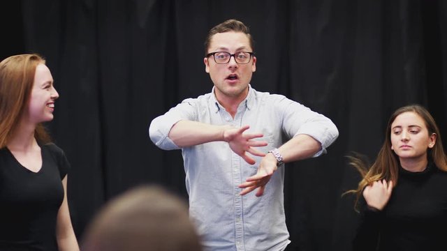 Teacher With Female Drama Students At Performing Arts School In Studio Improvisation Class