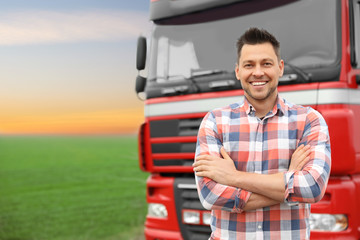Portrait of driver at modern truck outdoors. Space for text