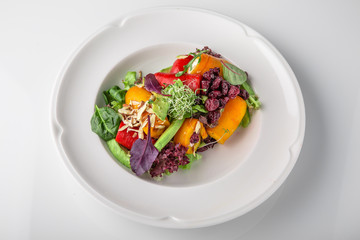 Salad of grilled vegetables in combination with fresh vegetables, cheese and sprouts of micro...
