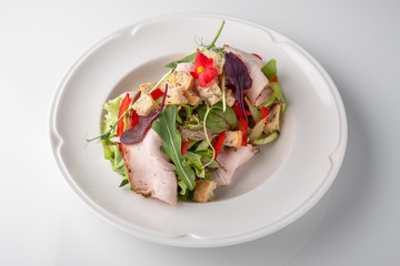 Salad of ham, prosciutto, pork or beef with vegetables, greens, berries and sauce. Nutritious, healthy dish. Banquet festive dishes. Gourmet restaurant menu. White background.