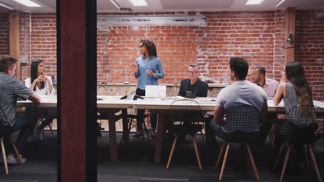 Business Team Having Late Night Meeting Sitting Around Boardroom Table
