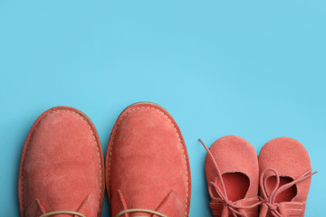 Big and small coral shoes on light blue background, top view. Space for text