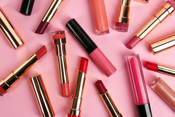 Set of bright lipsticks on pink background, flat lay
