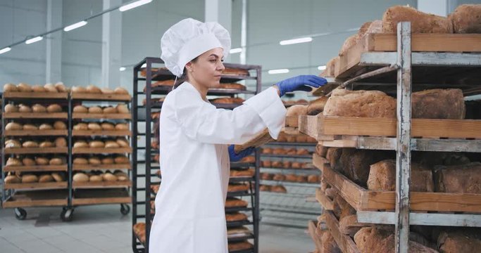 Woman baker very attractive place on the order the fresh baked bread she wearing stylish uniform for baker