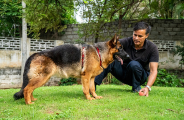 German Shepherd with Handler in Garden