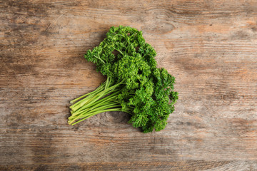 Bunch of fresh green parsley on wooden table, top view