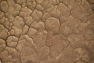 Dry cracked earth during in a rainy season because lack of rain shortage of water cracked soil texture