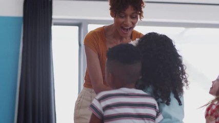 Group Of Elementary School Pupils Giving Female Teacher Thank You Gift Of Flowers
