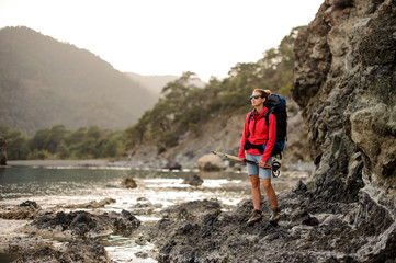 Naklejka premium Female hiker stands with hiking sticks in hands